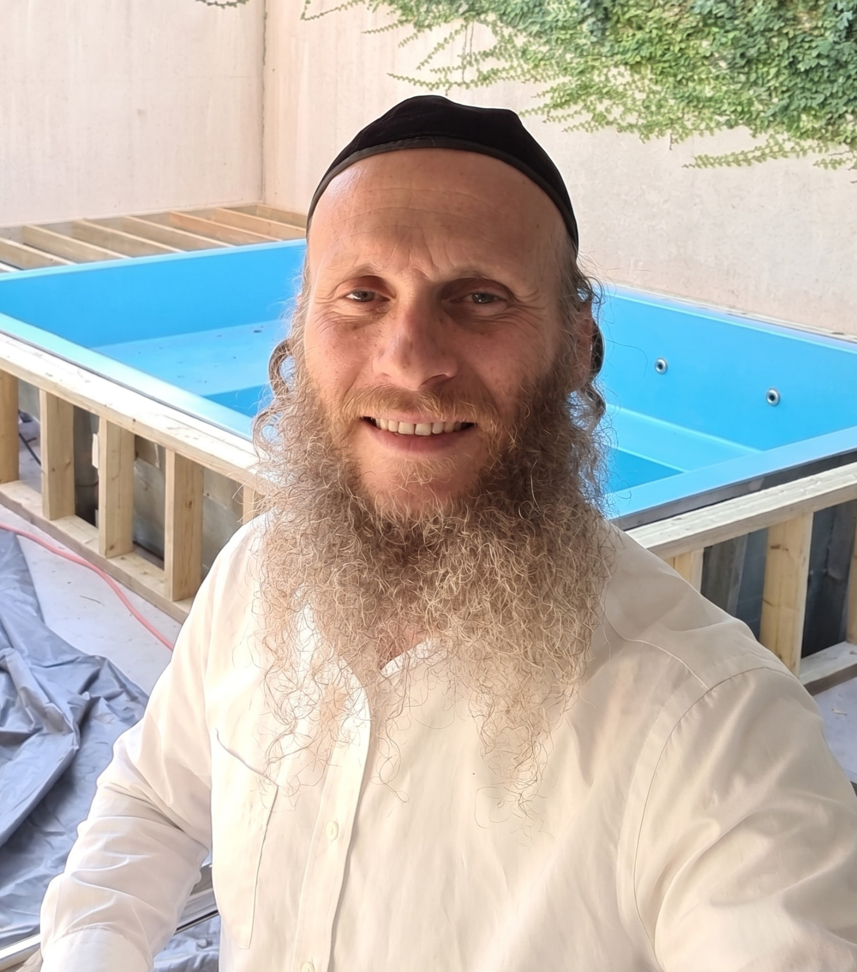 דוד אנג'ל באתר עבודה לצד בריכה בבנייה