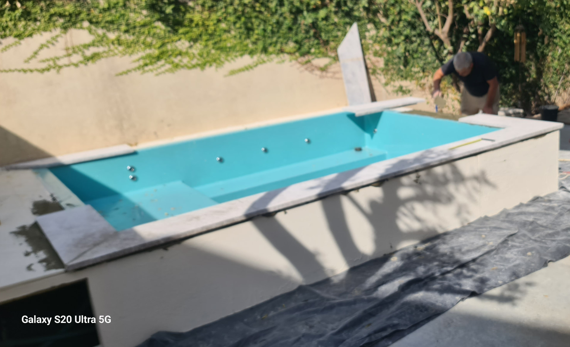 בריכה 4 על 2.5 לקראת סיום חיפוי אבן מסביב